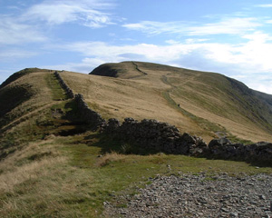 High Street with the Roman road ascending to the right of the stone wall